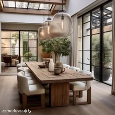 a dining room table with chairs and lights hanging from it's centerpieces