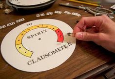 a person is cutting out some type of sticker on a table with scissors and other crafting supplies