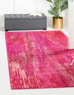 a bright pink rug in the corner of a room with a couch and potted plant