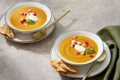 two white bowls filled with soup and topped with sour cream