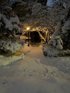 a snow covered path leading to a light at night