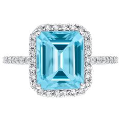 an aqua blue topazte and diamond ring with white diamonds on the sides, set in