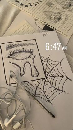 an image of a spider web drawing with headphones on the table next to it