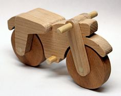 a wooden toy bike with wheels on a white background