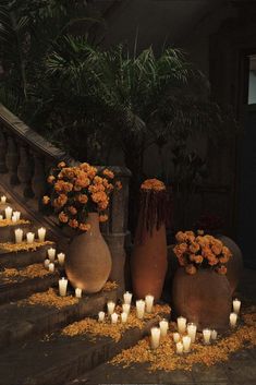 several vases with flowers and candles on the steps