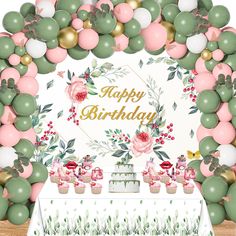 a birthday party with balloons, cake and cupcakes in front of a floral arch