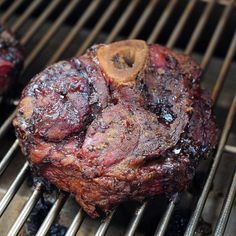 two steaks cooking on top of a grill