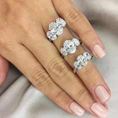 a woman's hand with three diamond rings on her left and the middle finger