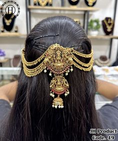 the back of a woman's head with gold jewelry on it