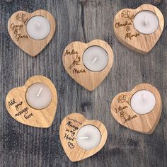 wooden heart shaped tea light holders with personalized names and candles in them on a table