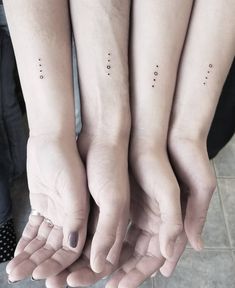 three people with matching tattoos on their hands