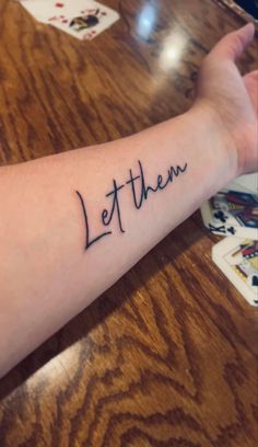 a person with a tattoo on their arm that says let them