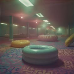 inflatables are lined up on the carpet inside an empty room with lights