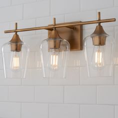 three lights are hanging on the wall