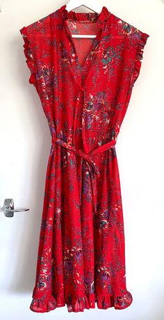 A cute brightly printed floral ruffle dress, in an electric red colour, with energetic floral motifs. Made of polyester so has a 70s/80s vibe to it. But I think it could be styled in a really fresh way with some white trainers and a denim jacket.  Great Condition and badly modelled by myself! Red Fitted Printed Floral Dress, Red Printed Fitted Floral Dress, Fitted Red Floral Printed Dress, Fitted Red Printed Floral Dress, Red Bohemian Floral Dress For Spring, Bohemian Red Floral Dress For Spring, Red Printed Floral Dress For Spring, Red Retro Dress For Spring, Retro Red Dress For Spring