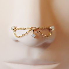 a white mannequin head with gold chains and charms on it