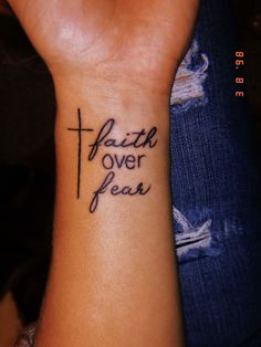 a woman's wrist tattoo with the words faith over fear