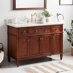 a bathroom with a sink, mirror and rug