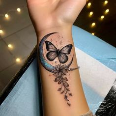 a woman's arm with a butterfly on it and a crescent tattoo design in the middle