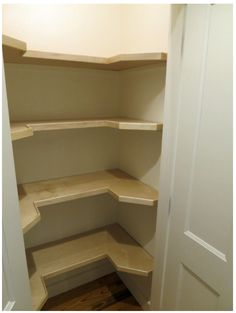 an empty walk - in closet with shelves on the wall and wood flooring underneath