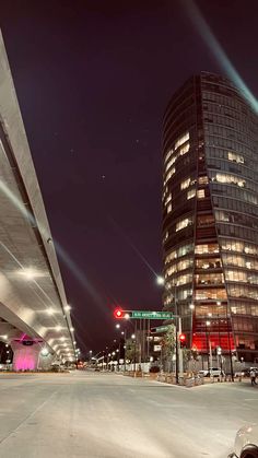 an empty parking lot next to a tall building at night