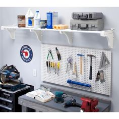 a workbench with tools hanging on the wall and pegs attached to it