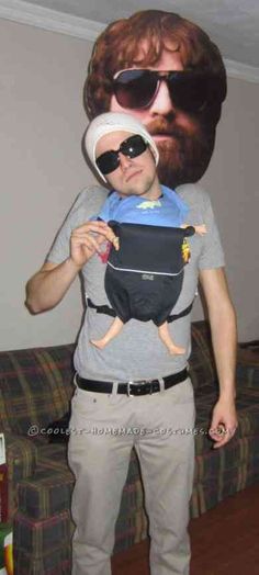 a man in sunglasses and a beard is holding up a bag with a doll on it