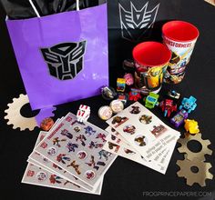 a table topped with paper bags and stickers next to cup filled with candies