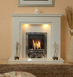 a fire place in a living room next to a vase with flowers on the table