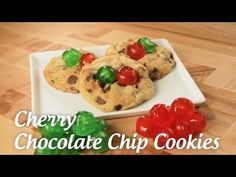 three cookies on a white plate with cherries and chocolate chips in the background text cherry chocolate chip cookies