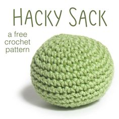 a green crochet ball sitting on top of a white surface with the words hacky sack written below it