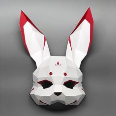 an origami rabbit mask is shown on a gray background, with red and white details