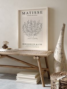 a wooden table with a vase on it next to books and a wicker basket