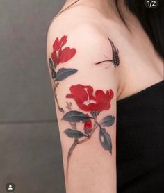 a woman's arm with red flowers and a butterfly tattoo on her left shoulder