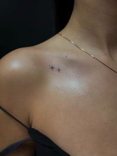 a woman's chest with two small stars on the left side of her shoulder