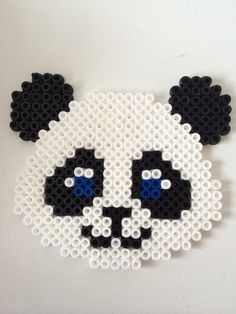 a black and white panda bear made out of legos with blue eyes on it's face