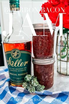 a bottle of booze next to a jar of jam on a checkered table cloth