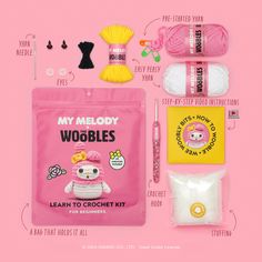 the contents of a crochet kit including yarn, scissors and knitting needles on a pink background