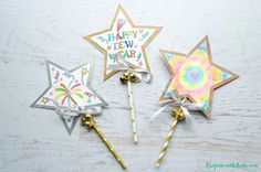 three star shaped lollipop sticks with happy new year's decorations on them