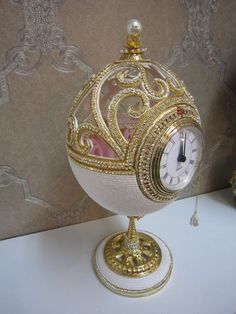 a white and gold clock sitting on top of a table