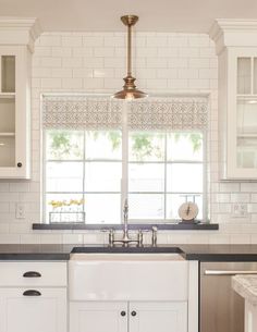 a kitchen with white cabinets and black counter tops