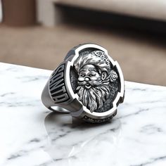 Celebrate the magic of the holiday season with this Santa Claus Christmas Saint Nicholas Believe Ring, exquisitely crafted from 925 sterling silver. This unique ring features a detailed design of Santa Claus, symbolizing joy, generosity, and the spirit of Christmas. Perfect for both men and women, this festive statement piece adds a touch of holiday cheer to any outfit. The adjustable band ensures a comfortable fit, making it an ideal addition to your seasonal jewelry collection. Whether you're Viking Ring, Masonic Ring, Retro Ring, Animal Rings, Saint Nicholas, Santa Claus Christmas, Everyday Rings, Detailed Design, Cross Ring