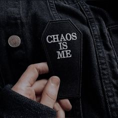 a person wearing a black jacket with the words chaos is me on it and a white patch reading chaos is me