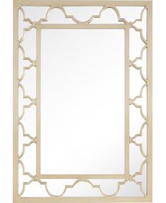 a mirror that is sitting on top of a white surface and has an intricate design