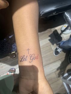 a person with a tattoo on their arm that says let god