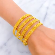 This festive set consists of four bangles, each crafted from 22k yellow gold, weighing a total of 47.9 grams. Embellished with shiny beadwork, these bangles shine with a celebratory sparkle, making them a perfect addition to any festive occasion. Sized at 2.7 with an opening of 2.45 inches, they are designed to fit comfortably while providing a dazzling display of craftsmanship. The beadwork adds texture and depth to the bangles, enhancing their visual appeal and making them stand out in any jewelry collection. Ideal for those looking to add a touch of festivity and elegance to their attire, these bangles merge traditional design with a modern twist. PRODUCT DETAILS Gold Purity(karat): 22k Gold Weight(grams): 47.9 Item Finish: Yellow Gold Bangle Size: 2.7 Bangle Opening: ﻿2.45" Number Of P Gold Beaded Bracelets For Diwali, Traditional Yellow Gold Bangle For Celebration, Gold Beaded Bangle Bracelet For Celebration, Festive Gold Beaded Bangle Bracelets, Traditional Gold Beaded Bracelets For Celebration, Hand Set Yellow Gold Bangle For Celebration, Traditional Yellow Gold Bracelets For Celebration, Elegant Gold Beaded Bracelets For Festive Occasions, Traditional Yellow Bangle Bracelet