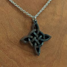 a wooden cross on a chain with an intricate design in the shape of a star