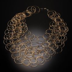 Gold & Steel Necklace - Hand-formed rings of 14k gold-plated stainless steel cable create a tumbling cascade of interconnected links on this lightweight necklace. The overlapping circles create a unique pattern reminiscent of Venn diagrams. Neodymium magnet clasp. Modern Multi-strand Chain Jewelry, Modern Multi-strand Gold Jewelry, Modern Gold Multi-strand Jewelry, Modern Gold Spiral Jewelry, Multi-strand Yellow Gold Metal Jewelry, Wire Lace Jewelry, Venn Diagrams, Overlapping Circles, Creative Necklace