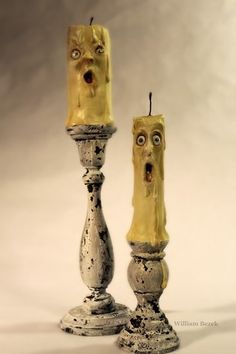 two yellow candles with faces on them and one has a surprised look to it's face