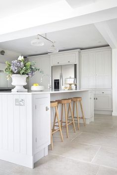 a kitchen with two stools and a center island in the middle of the room